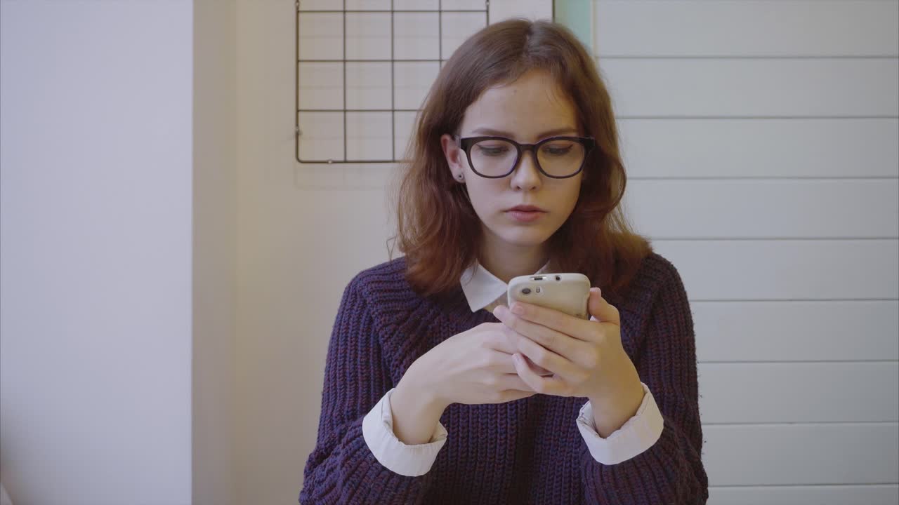 Teenager using a smartphone in a cafe