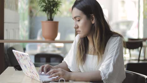 serious young woman working at a laptop