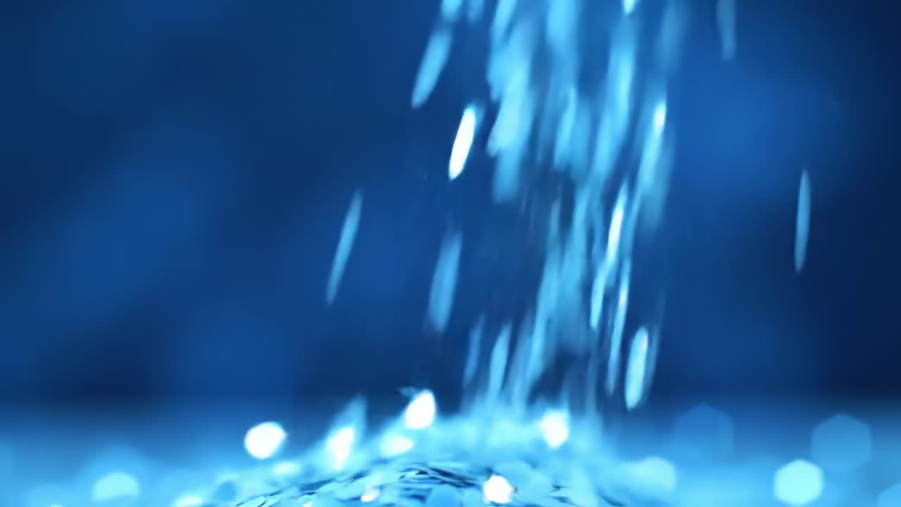 Water cascades gracefully in soft patterns, creating a calming ambiance. The droplets shimmer in soft light, captivating viewers with their movement. A tranquil escape into nature's beauty.