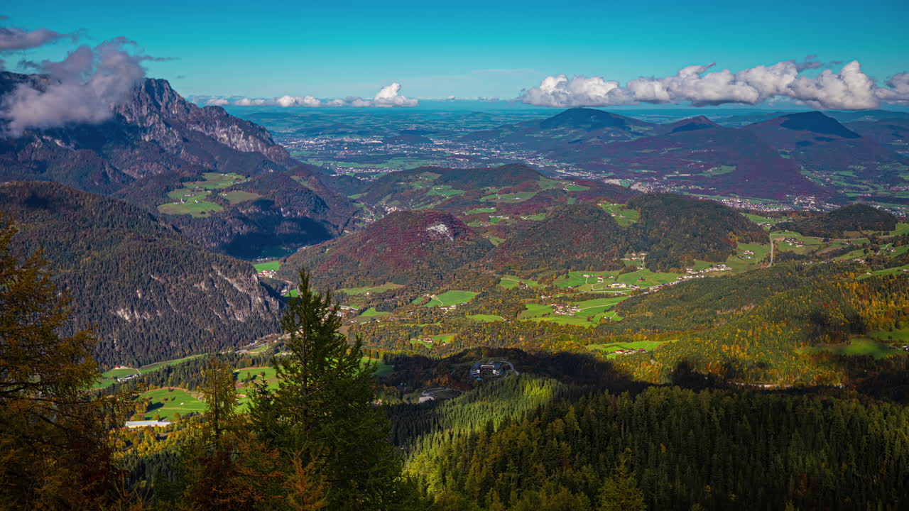 높은 산 정상에 둘러싸인 두꺼운 식물이 있는 녹색 계곡 위에 떠다니는 움직이는 구름의 타임 ⁇ 스 영상