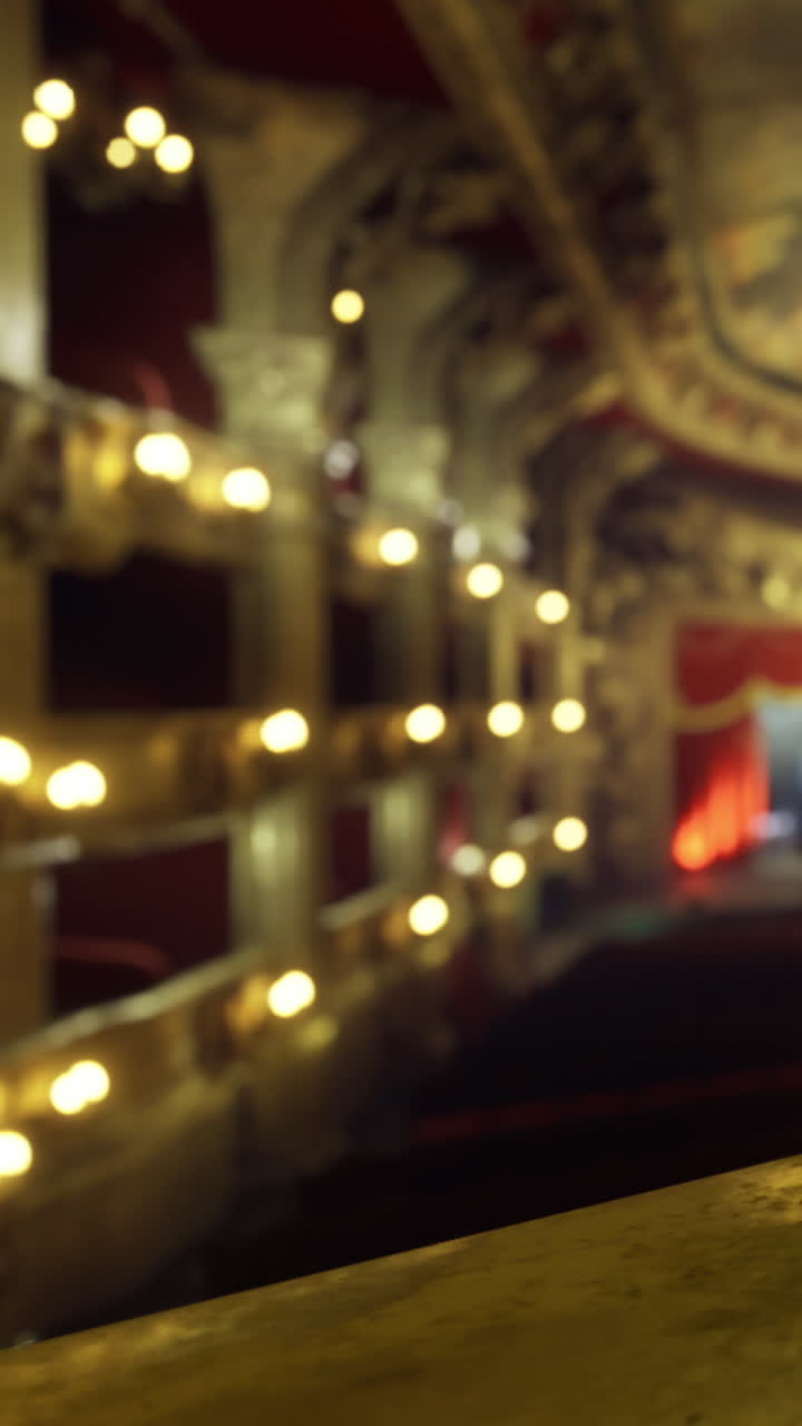 Veduta di un interno di teatro con luci e decorazioni sullo sfondo.