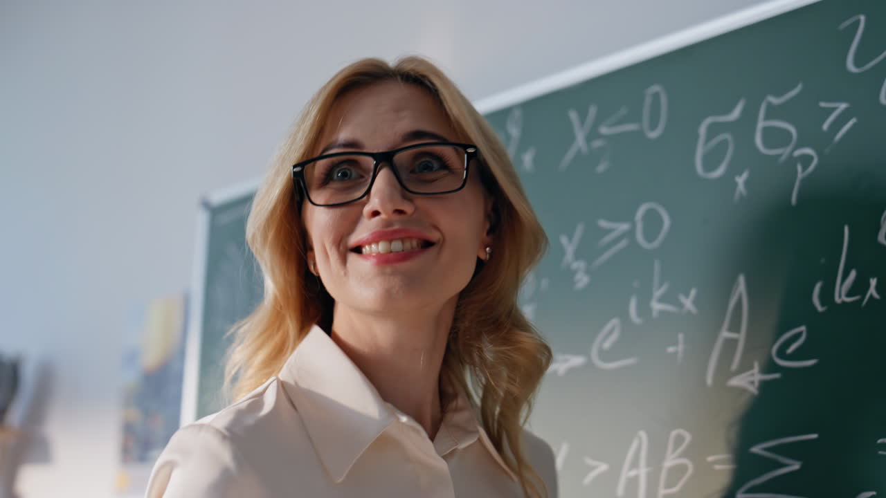 Teacher hand writing formulas on blackboard school closeup. Woman teaching