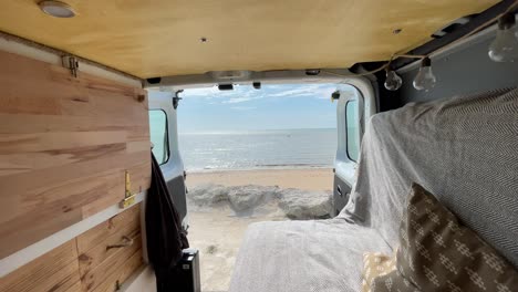 vista estática desde el interior de una furgoneta amueblada de un magnífico panorama del mar