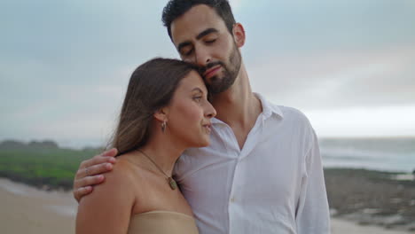 lovely family cuddling at misty ocean closeup. happy pair walking beach vertical