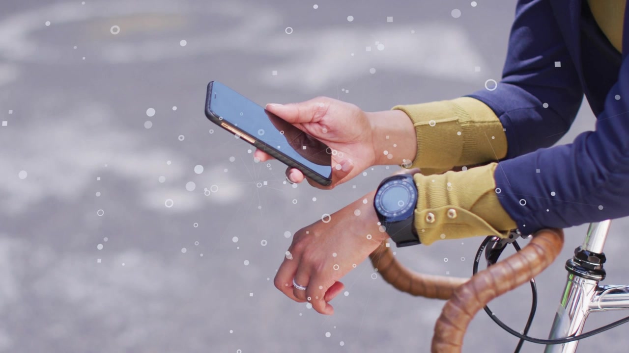 Ciclista donna che tocca il telefono dopo una vibrazione, controllando l'app per il tragitto casa-lavoro, orologio sul manubrio, bokeh sulle mani.