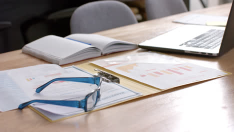 documents and laptop on table at home, slow motion