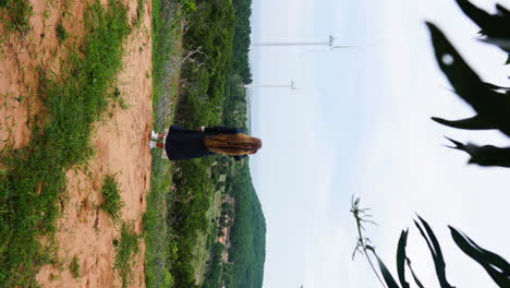 Una-Chica-De-Cabello-Largo-Disfrutando-De-La-Vista-Escénica-De-La-Granja-De-Molinos-De-Viento-En-Un-Clima-Nublado