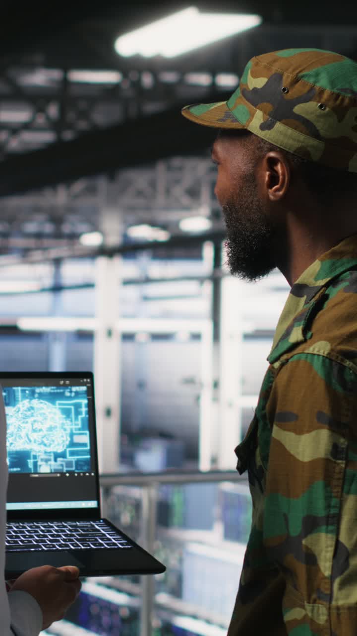 Vertical video Military technicians in secure data center use laptop to monitor AI systems
