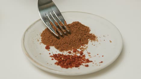 blended paprika and parsley on a plate with white background