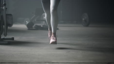 woman standing on start position. female jogger legs running in sport club