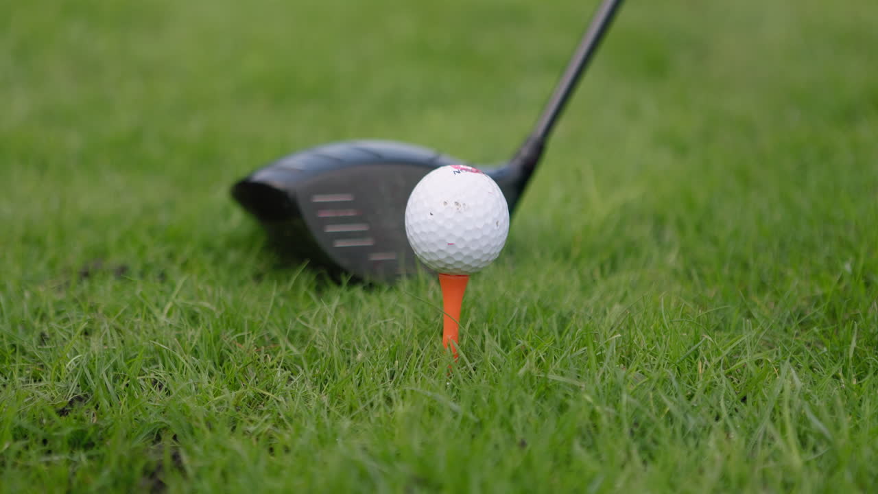 Golfing equipment and a hand placing a golf ball