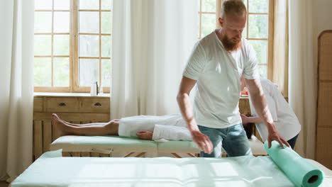 Man-preparing-stretcher-for-massage