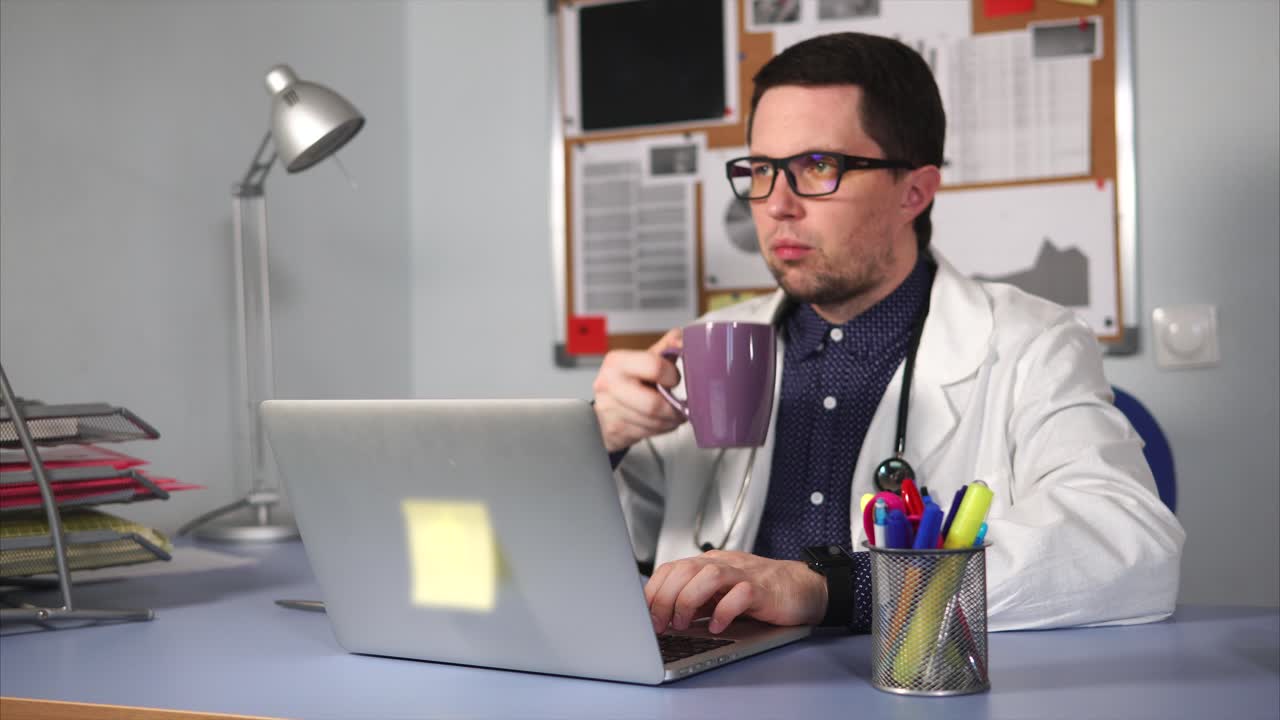 médico trabajando en una computadora portátil en la oficina