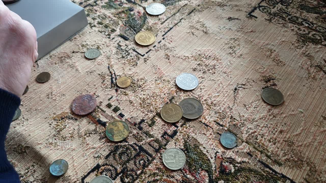 el evaluador de monedas, el coleccionista de monedas. el hombre considera las monedas antiguas.