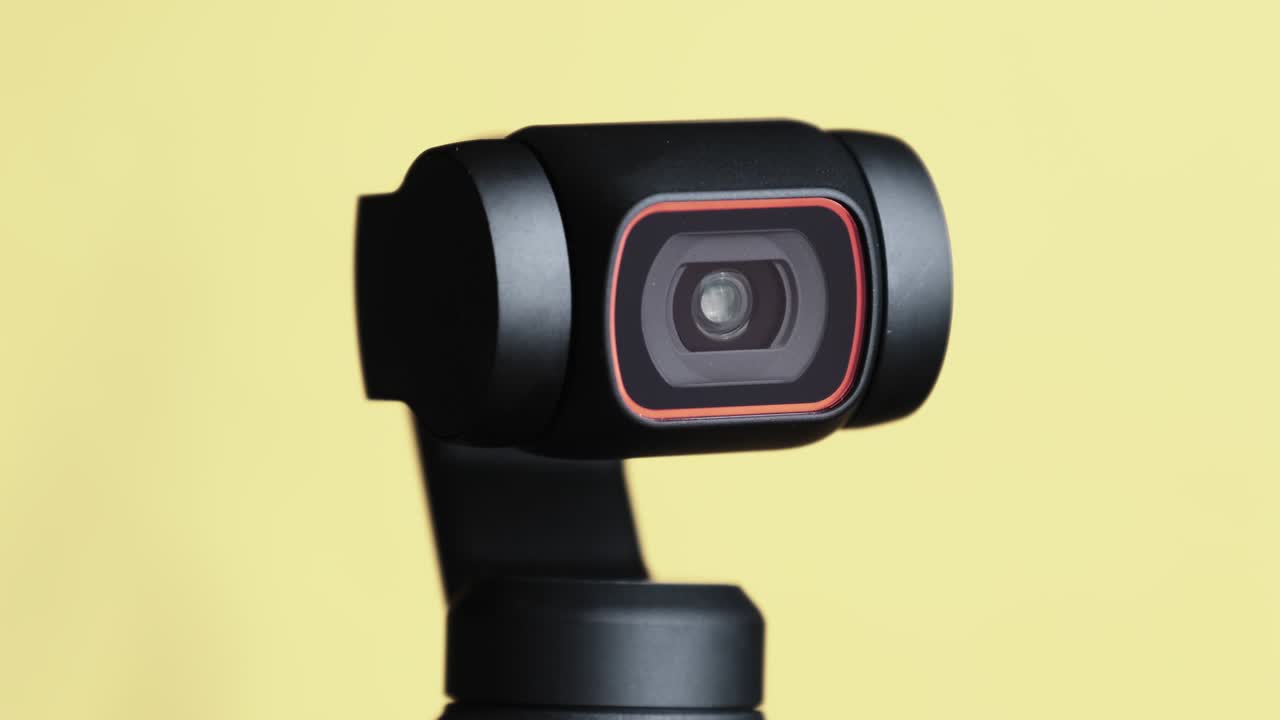 Mechanical Gimbal Camera Lens Rotates on Yellow Background, Robotic Camera Macro