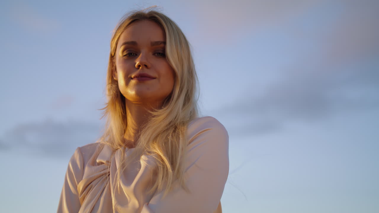 Sunset blonde posing nature blue sky portrait. Smiling woman face looking camera