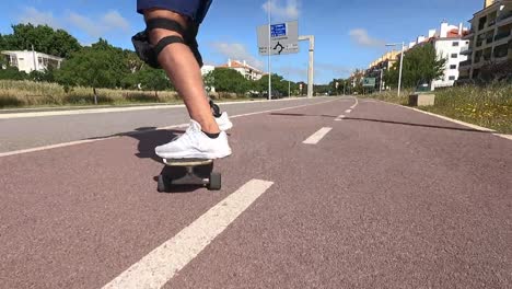 Disabled-man-with-a-prosthetic-leg-skateboarding-and-riding-a-skateboard,-outdoor-low-angle-close-up