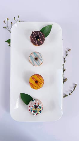 colorful glazed donuts on a white plate