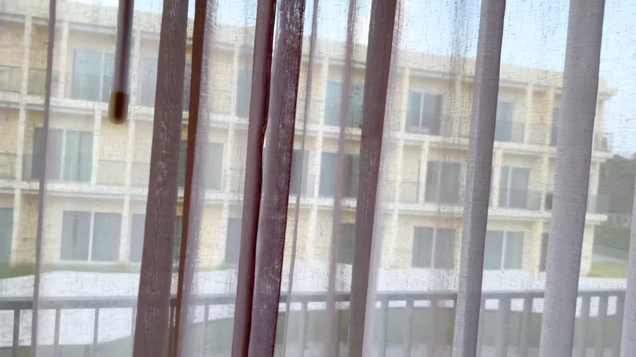 커튼이 열리면 밖의 아파트 건물이 드러납니다.