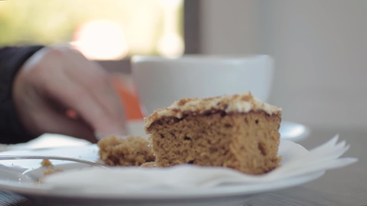 cena en la cafetería disfrutando de una taza de café y pastel de zanahoria.