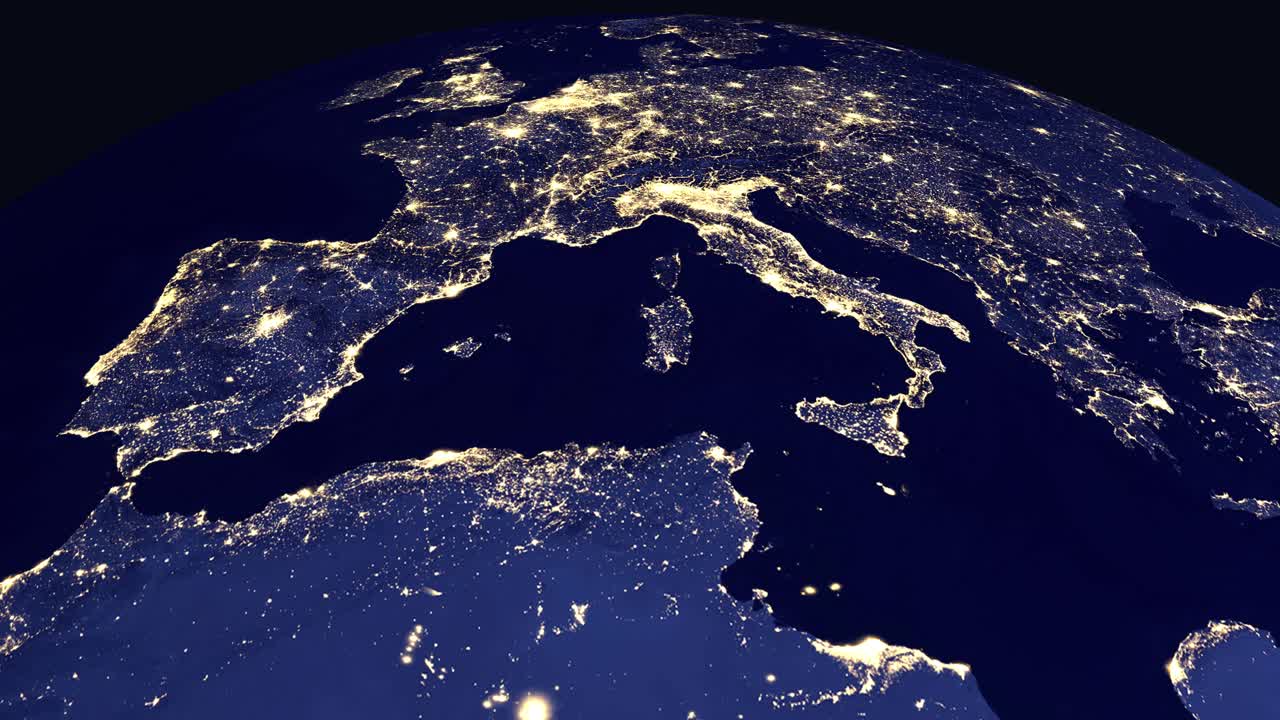 Digital globe rotates and zooms into North Africa and Europe showing city lights at night
