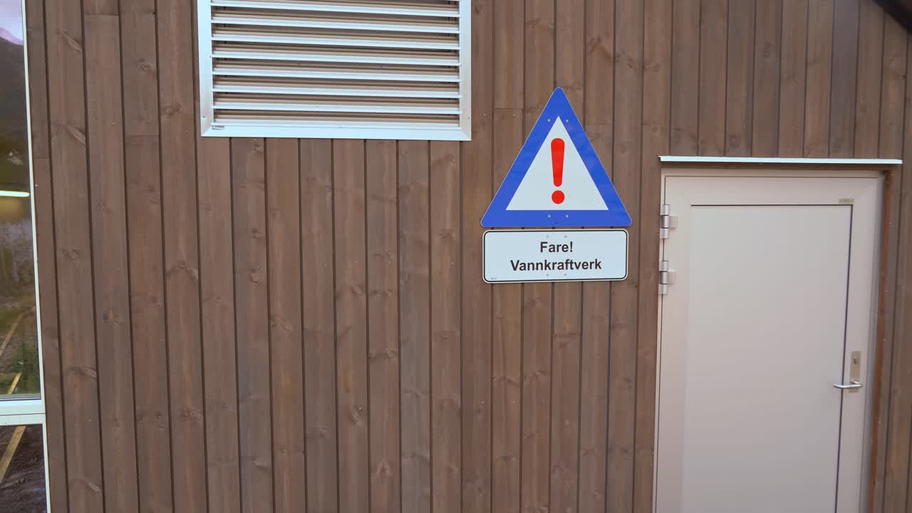 Sign warning about hydroelectric powerplant on wall of Markaani powerplant in Vaksdal Norway