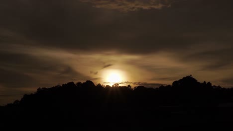 beautiful sunrise over wild jungle mountains with rolling clouds in nature indonesia time lapse