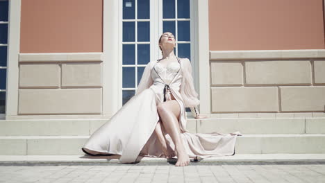 woman in a luxurious robe sitting on steps