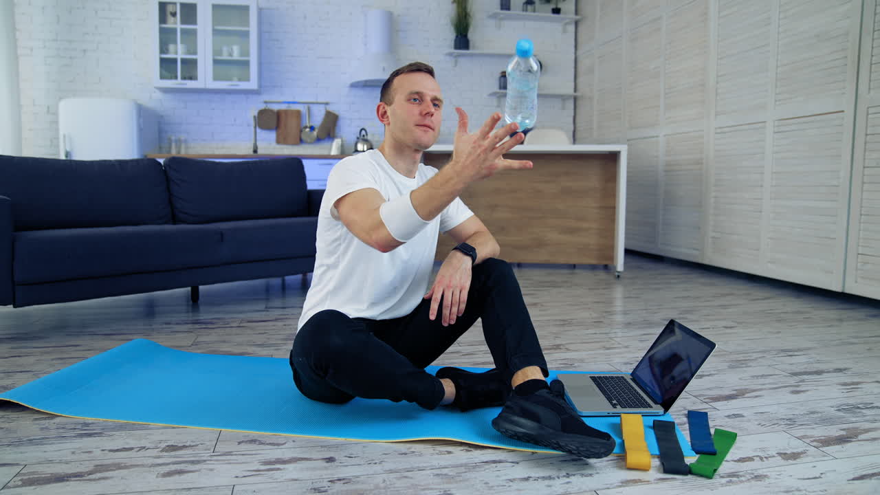 Man after exercise at home. Male sportsman resting after online fitness at home