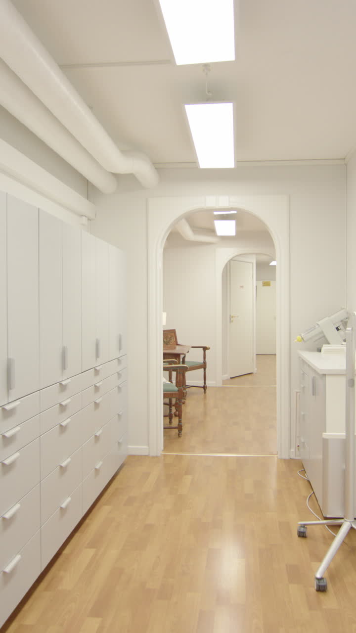 POV walking down modern lit up corridor of health centre, vertical