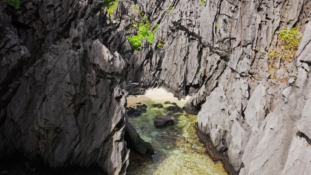 Küçük, gizli, plastik atıklarla dolu plaj, tropikal kireçtaşı karst kayalıkları.