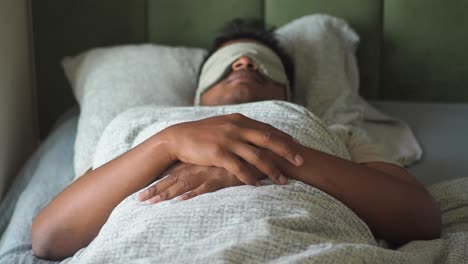 a person sleeping soundly in bed with a sleep mask on