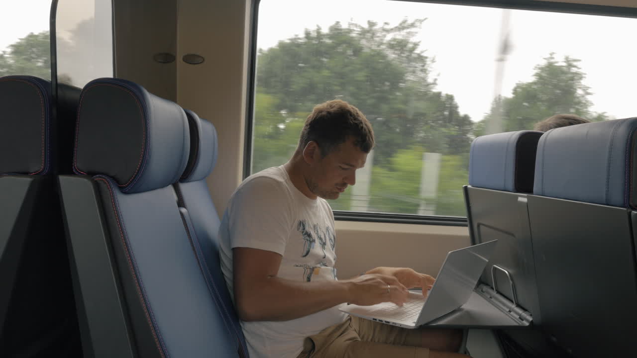 hombre usando una computadora portátil durante un viaje en un tren de cercanías
