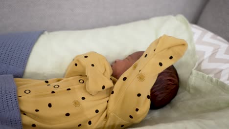 a precious moment of a 1-week-old newborn baby peacefully sleeping in a yellow-dotted pajama, epitomizing the serene essence of newborns and infants