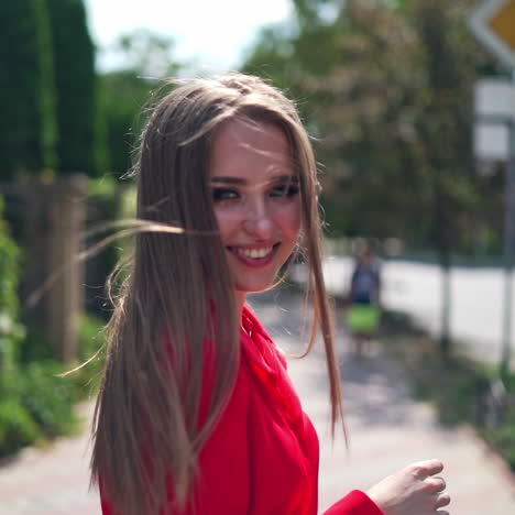 Smiling pretty woman in the street. Beautiful young model with long hair walking happily in the city and looking at camera. Slow motion.