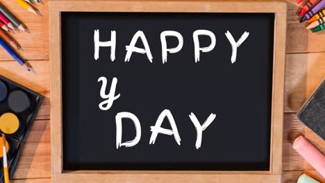 Animation-of-happy-youth-day-text-over-blackboard-on-desk