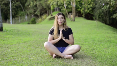 woman prays and meditates in green field