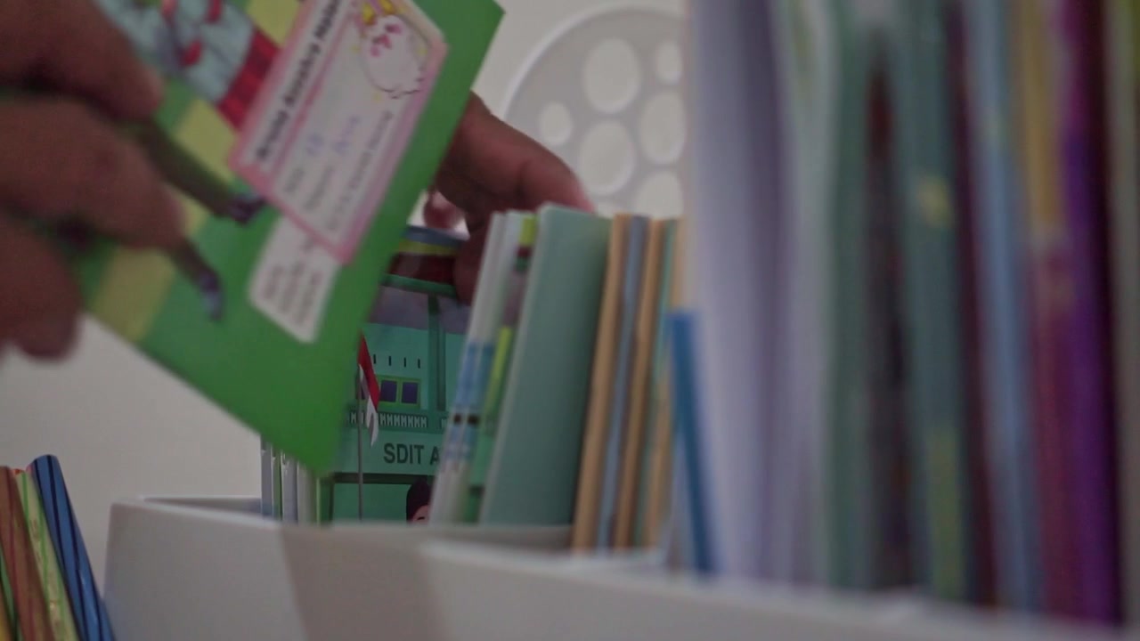 hand placing book back on colorful shelf, organizing bookshelf, reading and education organization concept.