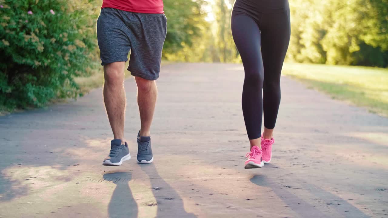 sección baja de pareja corriendo en el parque, katowice, polonia