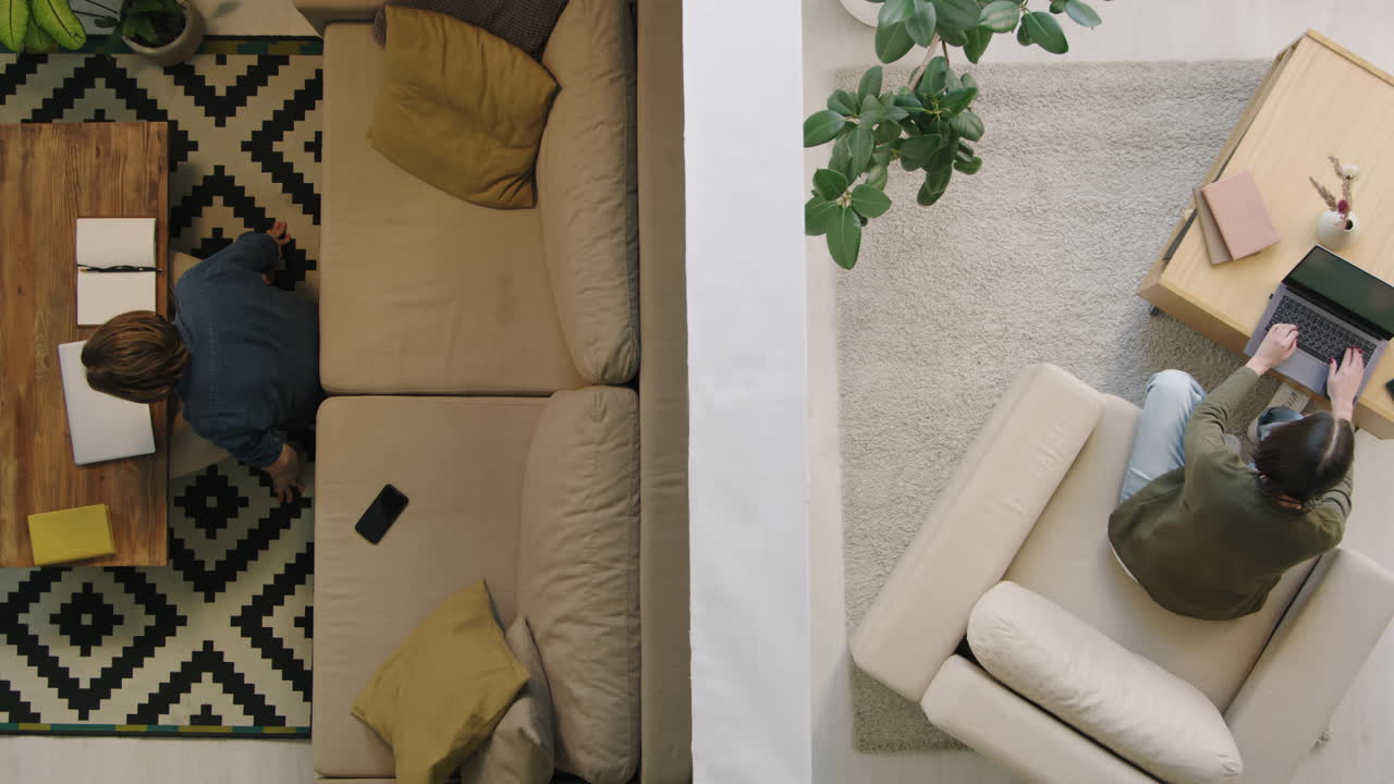 Overhead view of people working on laptops and relaxing on sofas