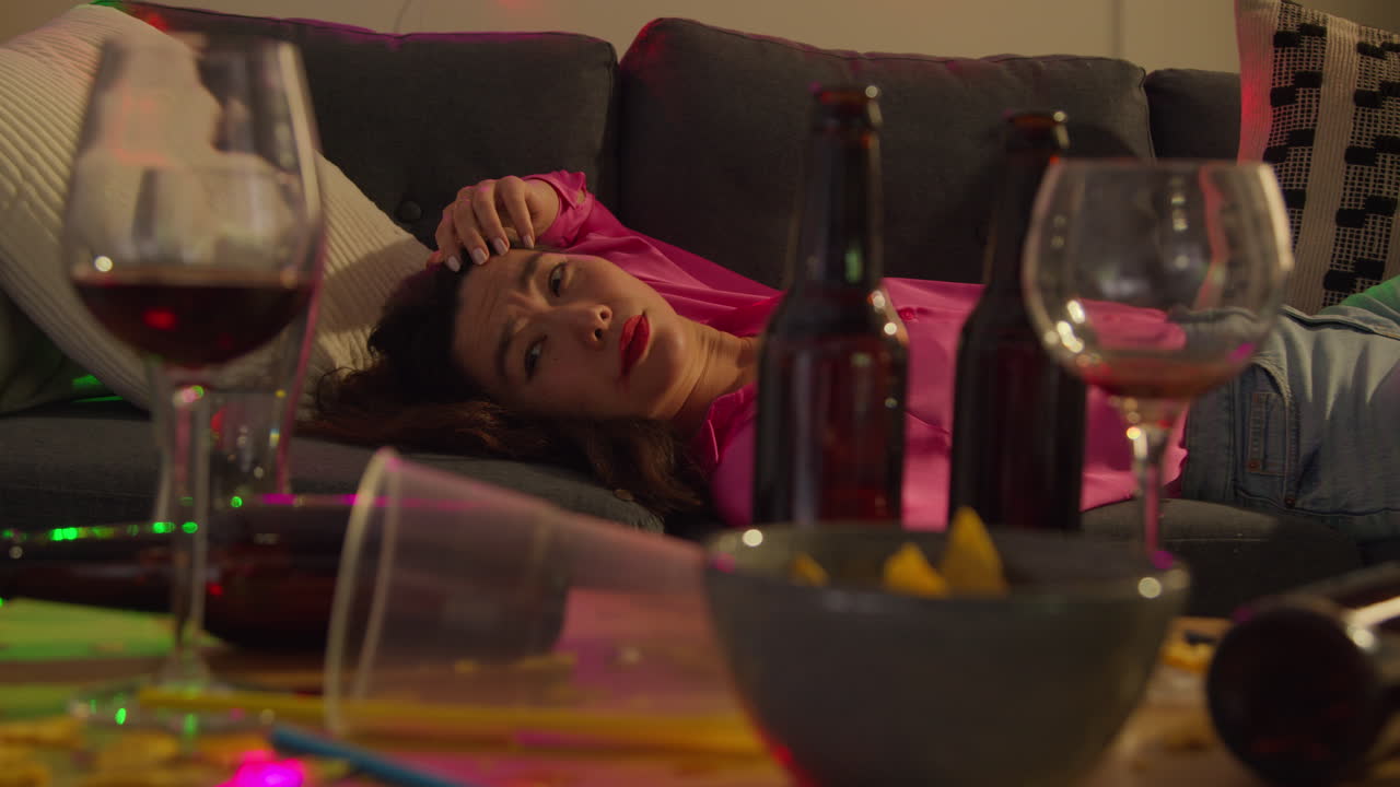 집 파티에서 알코올을 마신 후 소파에서 깨어난 여성이 숙취로 고통 받고 있습니다.