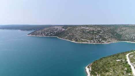 croatian beach sea coast of pula rakalj, aerial drone fly above idyllic bay of pristine blue water in european summer, travel and tourism