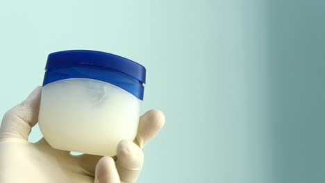 hand holding a container of petroleum jelly