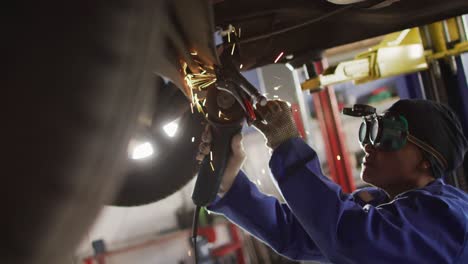 Video-of-african-american-female-car-mechanic-using-grinder