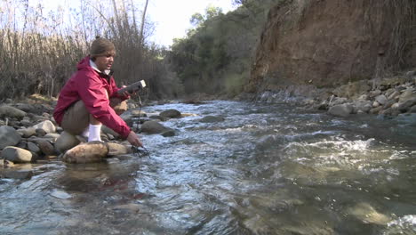 man testing the water flowing in san antonio creek in ojai california