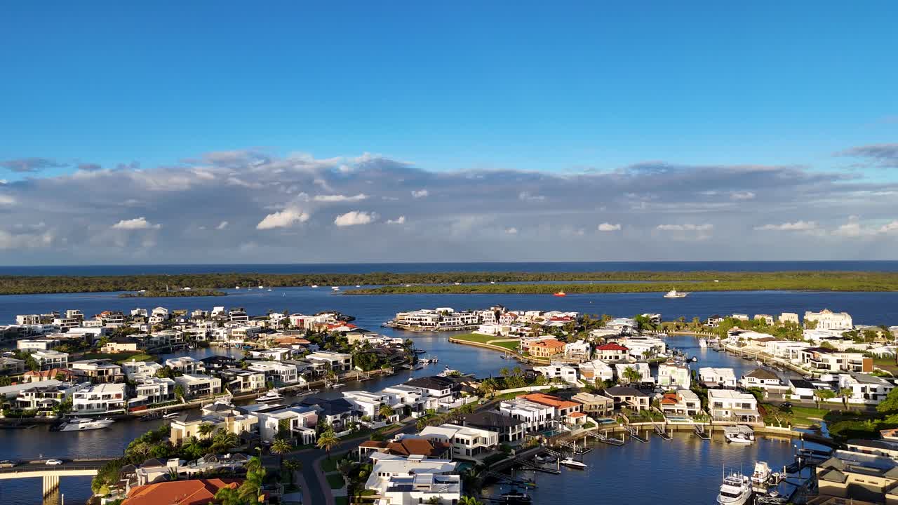 Drone captures stunning aerial views of luxury estates along Gold Coast waterways under clear blue skies