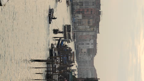 vertical shot of grand canal with gondolier calmly paddling, venice, italy