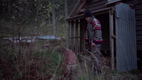 Man-Wearing-Sweater-Chopping-Log-Using-Axe-Outdoor