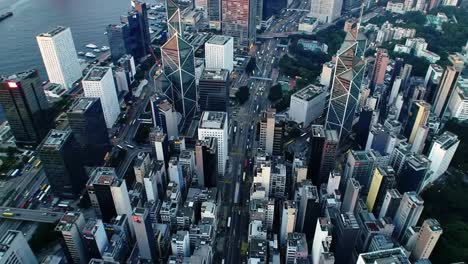 early morning in hong kong reveals a bustling city filled with high-rise buildings and busy streets. traffic flows as people begin their daily routines against a stunning skyline backdrop.