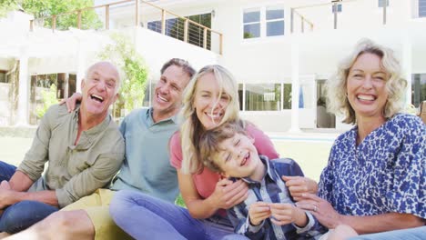 Porträt-Einer-Glücklichen-Kaukasischen-Familie,-Die-Im-Garten-Sitzt-Und-Sich-Umarmt